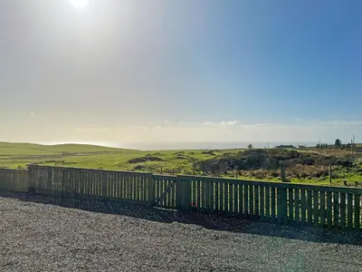 a wooden fence with the ocean in the background at Keith - Uk49287 in Stranraer