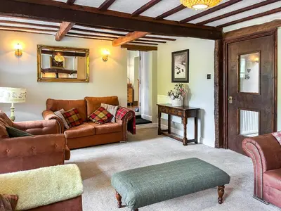 a living room with a couch and a table at Gillhead Farm Cottage in Troutbeck