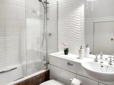 a bathroom with a shower and a sink and a toilet at Gillhead Farm Cottage in Troutbeck