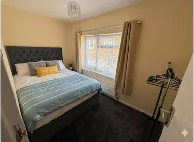 a small bedroom with a bed with a window at Nayla house in Moffat
