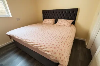 a bed with a black headboard and two pillows at Nayla house in Moffat