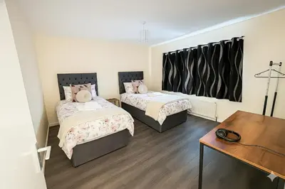 a room with two beds and a table and a desk at Nayla house in Moffat