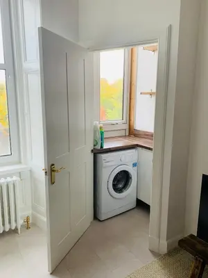 a laundry room with a washing machine and a window at Rachael's House in Moffat