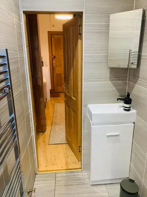 a bathroom with a toilet and a hallway with a door at Rachael's House in Moffat