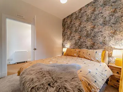 a bedroom with a bed with a floral accent wall at 2 Bed in Maybole 96012 in Maybole