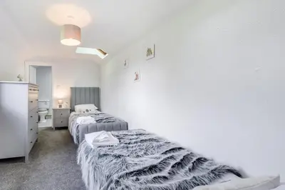 a bedroom with two beds and a white wall at 2 Bed in Troutbeck oc-b32579 in Troutbeck