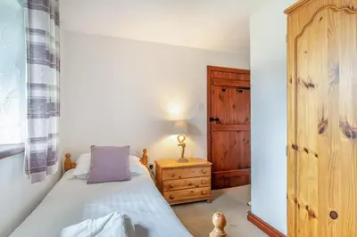 a bedroom with a bed and a wooden cabinet at 2 Bed in Troutbeck oc-s32564 in Troutbeck