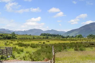 a fence in a field with mountains in the background at 2 Bed in Troutbeck oc-s32564 in Troutbeck