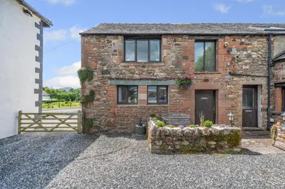 a brick house with a bench in front of it at 2 Bed in Troutbeck oc-s32564 in Troutbeck