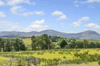 a field with a fence and mountains in the background at 2 Bed in Troutbeck oc-s32564 in Troutbeck