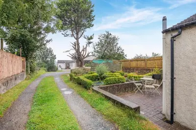 a garden with a table and chairs next to a house at 2 Bed in Aspatria oc-p32645 in Aspatria
