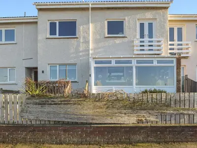 a house with a fence in front of it at Bay View in Maidens