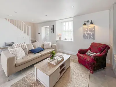 a living room with a couch and a chair at The Old Coach House At Balcary in Auchencairn