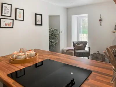 a living room with a table and a chair at The Old Coach House At Balcary in Auchencairn