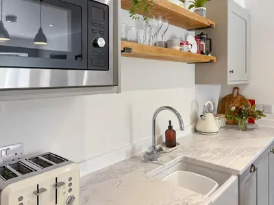 a kitchen with a sink and a microwave at The Old Coach House At Balcary in Auchencairn