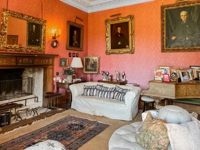 a living room with a couch and a fireplace at Amisfield Tower in Dumfries
