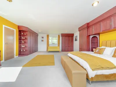 a bedroom with a large bed and wooden cabinets at Hydee House in Dumfries