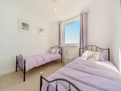 two beds in a room with purple sheets at Hydee House in Dumfries