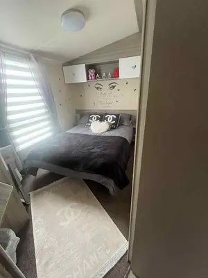 a bedroom with a bed in a small room at the heaths caravan hire Craig Tara in Minishant