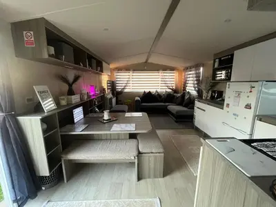 a kitchen and living room with a table and a couch at the heaths caravan hire Craig Tara in Minishant