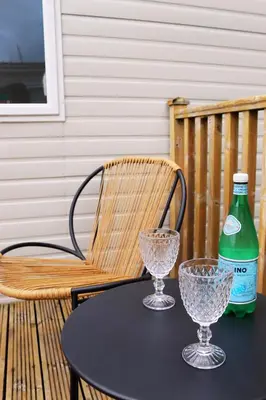 a table with two glasses and a bottle on a chair at Relax, Enjoy fast Starlink Wi-Fi in Carlisle
