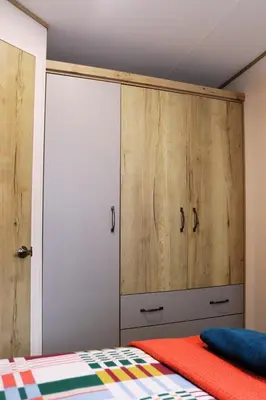a bedroom with a bed and a large wooden cabinet at Relax, Enjoy fast Starlink Wi-Fi in Carlisle