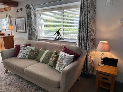 a living room with a couch and a window at Charming cosy cottage near the Lake District in Penrith