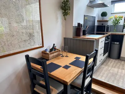 a kitchen with a wooden table with two chairs at Charming cosy cottage near the Lake District in Penrith