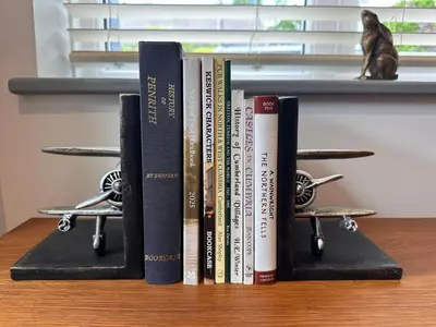 a group of books sitting on a shelf at Charming cosy cottage near the Lake District in Penrith