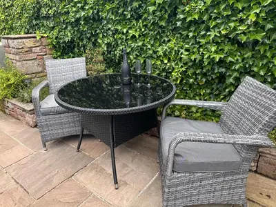 a patio table with two chairs and a umbrella at Charming cosy cottage near the Lake District in Penrith