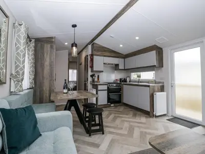 a kitchen and living room with a couch and a table at Puffin in St Bees