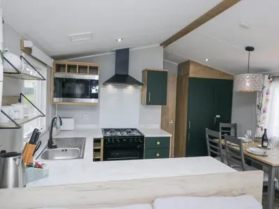 a kitchen with a sink and a stove top oven at Sandpiper in St Bees