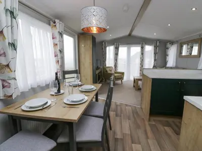 a dining room and kitchen with a table and chairs at Sandpiper in St Bees
