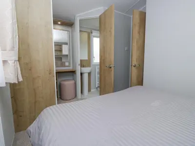 a bedroom with a white bed and a sink at Sandpiper in St Bees