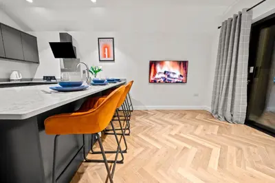 a kitchen with a counter and two chairs at a bar at The Salt Room Modern 1 Bedroom Home By AltoLuxo Short Lets Serviced Accommodation With Free Wifi & Parking in Moffat