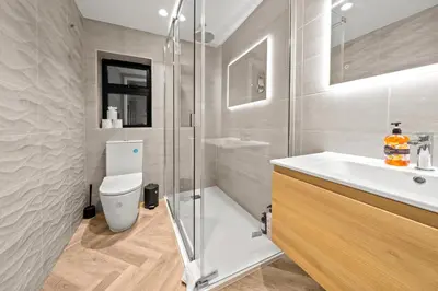 a bathroom with a shower and a toilet and a sink at The Salt Room Modern 1 Bedroom Home By AltoLuxo Short Lets Serviced Accommodation With Free Wifi & Parking in Moffat