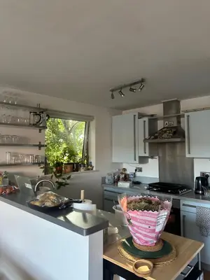 a kitchen with a table with a vase on it at Central London in Moffat