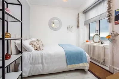 a white bedroom with a bed and a window at Sea view Villa Holiday and Corporate Let Accommodation in Prestwick