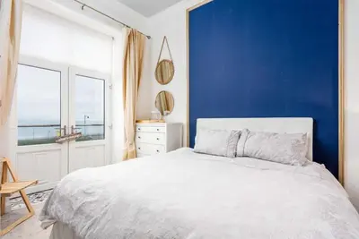 a bedroom with a white bed and a blue wall at Sea view Villa Holiday and Corporate Let Accommodation in Prestwick