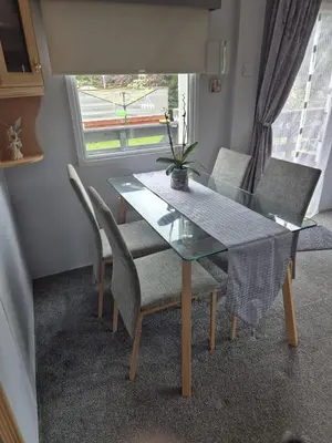a dining room with a glass table and chairs at Shep2 Caravans in Ballantrae