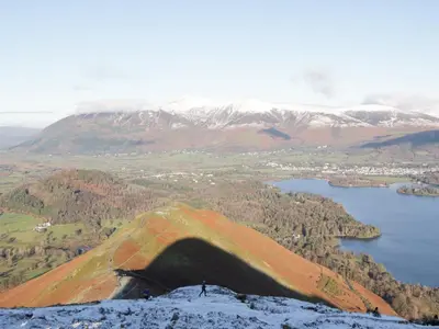 a person standing on top of a mountain at Swirl Howe in Keswick