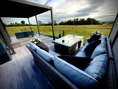 a patio with a couch and a table on a deck at Hamish's Hideaway in Eaglesfield
