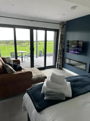 a bedroom with a bed and a living room with a couch at Hamish's Hideaway in Eaglesfield