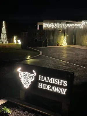a sign that reads hamidents hideaway at night at Hamish's Hideaway in Eaglesfield
