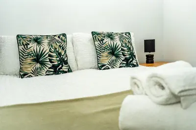 a white bed with two pillows on top of it at Bega House Apartment in Whitehaven