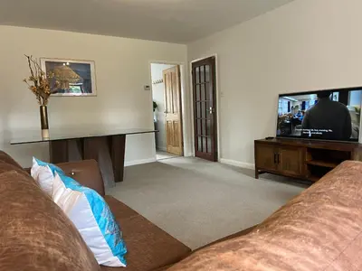 a living room with a couch and a flat screen tv at Stay Still Indian Court in Dalston