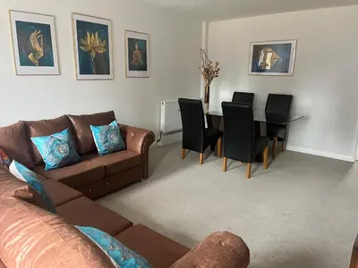 a living room with a couch and a table with chairs at Stay Still Indian Court in Dalston