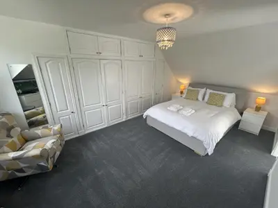 a white bedroom with a bed and a couch at The Stables in Symington in Symington