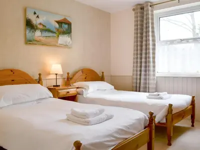 two twin beds in a room with a window at Brigham Farm Apartments in Keswick