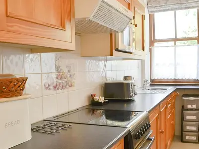 a kitchen with wooden cabinets and a stove top oven at Brigham Farm Apartments in Keswick